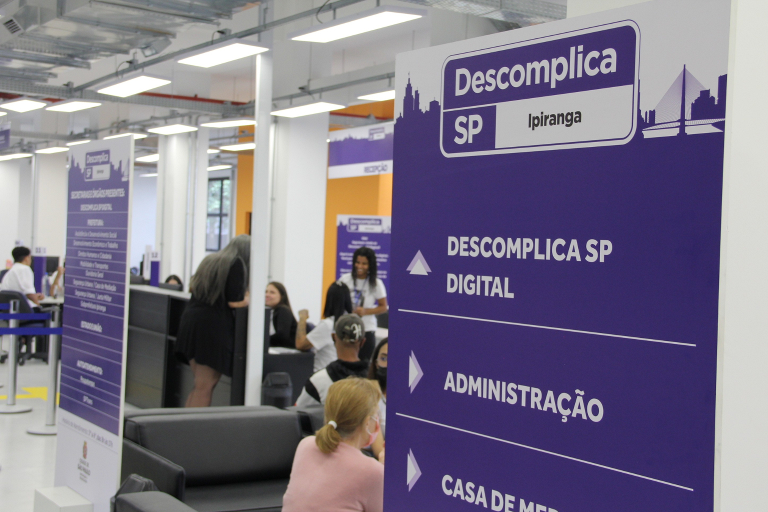 Imagem do Interior do Descomplica com placas de serviços oferecidos em azul e branco.